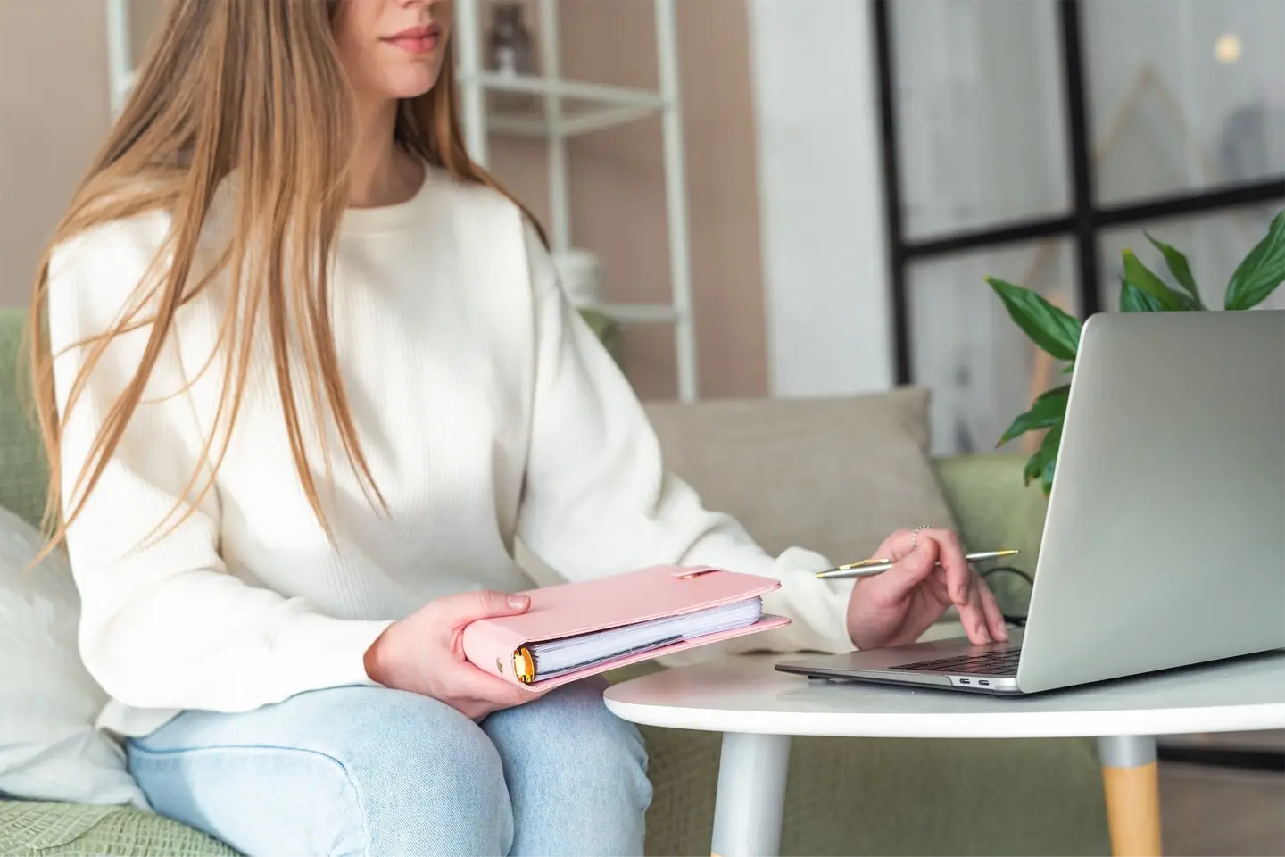 woman typing on laptop notebook holding notepad working home office online with technology